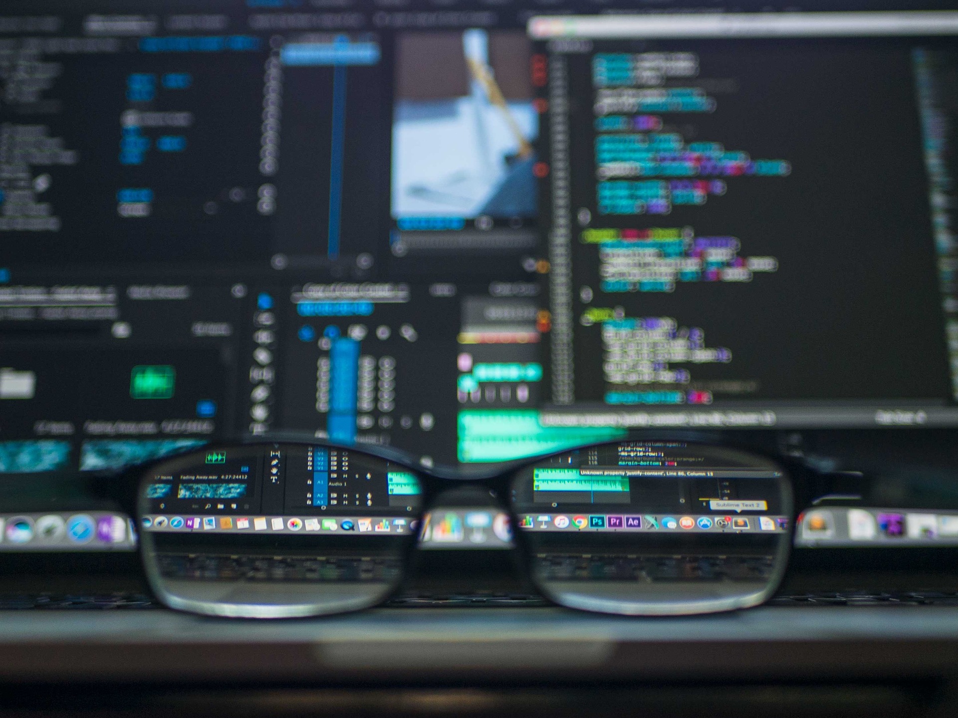 laptop focused on through a pair of glasses